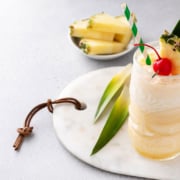 Ron Ron Cocolada Pina Colada Cocktail mit frischer Kokosnusscreme, garniert mit einer Scheibe Ananas und einer Moraschino-Kirsche