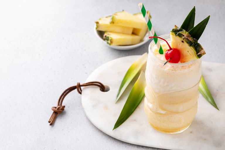 Ron Ron Cocolada Pina Colada Cocktail mit frischer Kokosnusscreme, garniert mit einer Scheibe Ananas und einer Moraschino-Kirsche