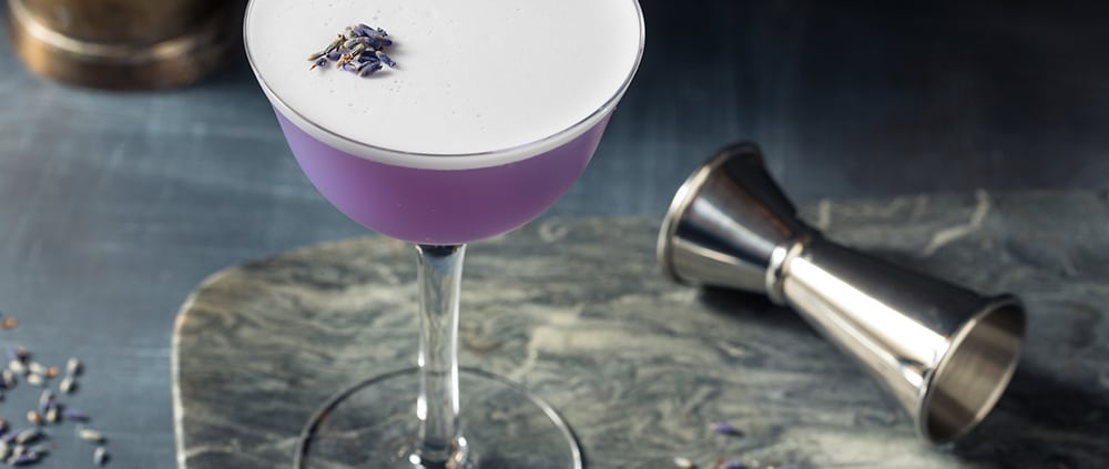Ron Ron – Lavanda ist ein Cocktail mit frischem Limettensaft und Lavendelsirup, auffällig ist die lila Farbe des Cocktails.